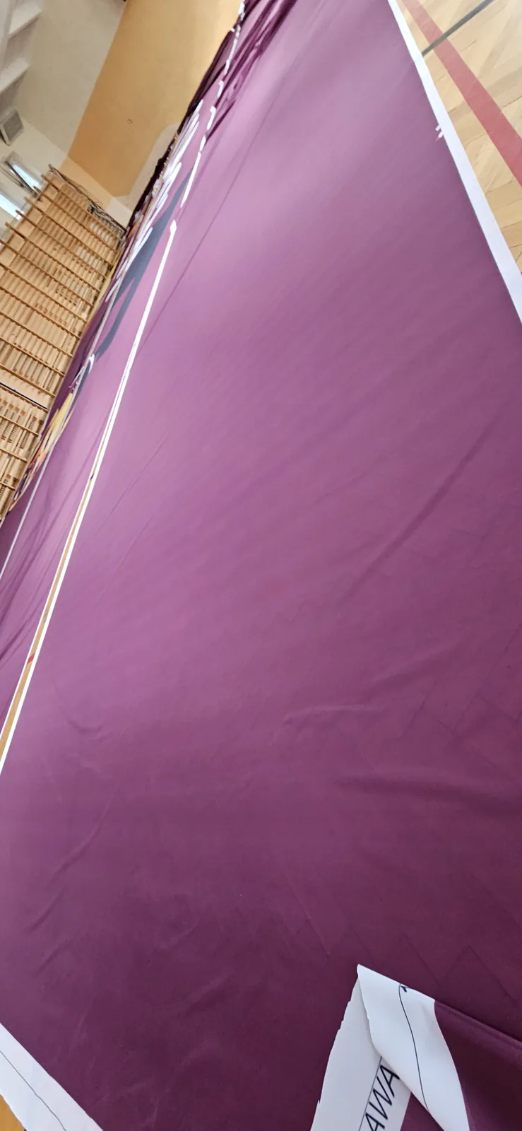 Purple sector flag with gold edge stripes being folded in the hall