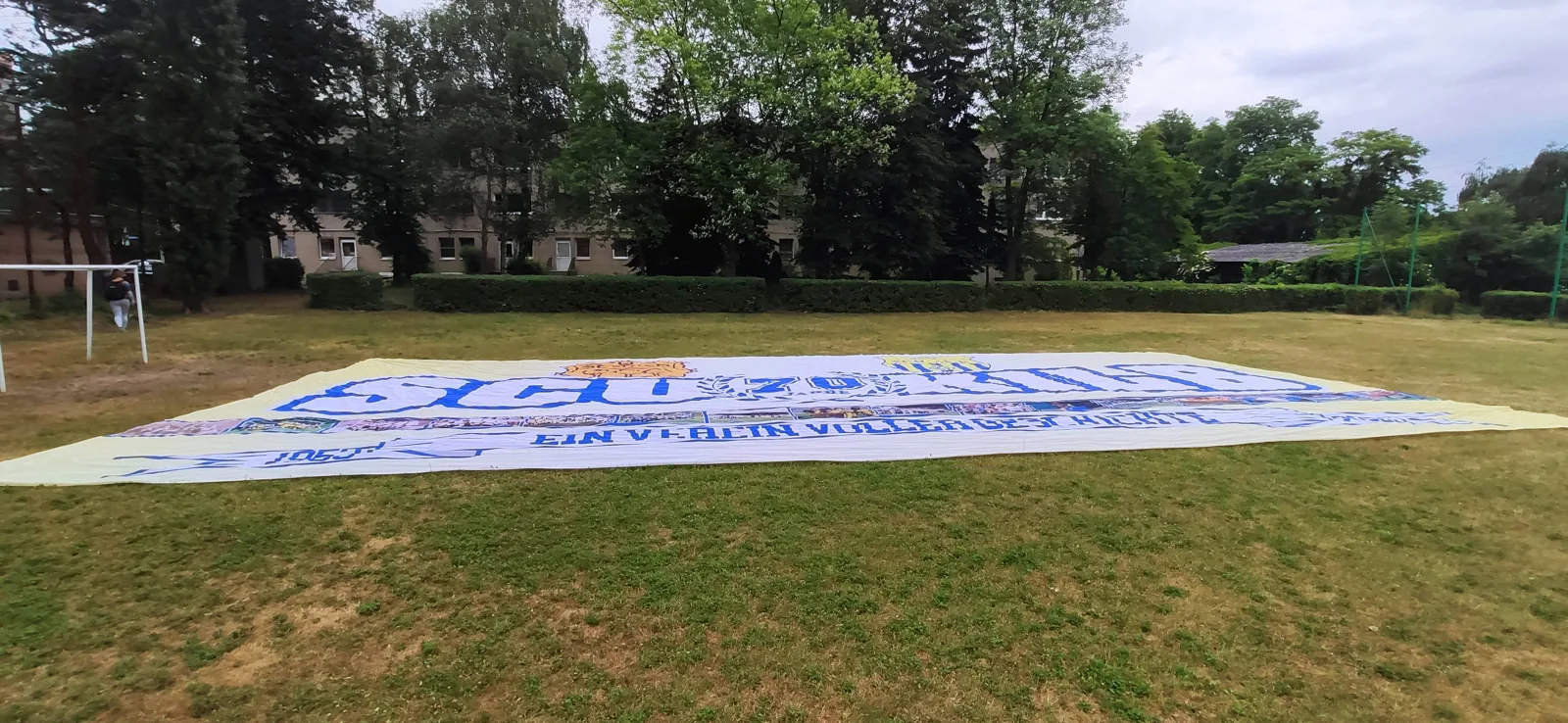 White sector flag with blue lettering checked outdoors before shipping