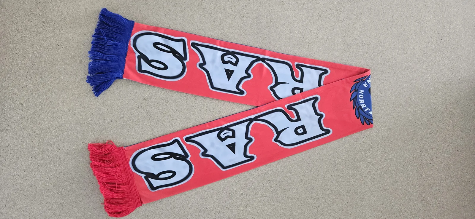 Two red scarves with blue lettering and blue tassels