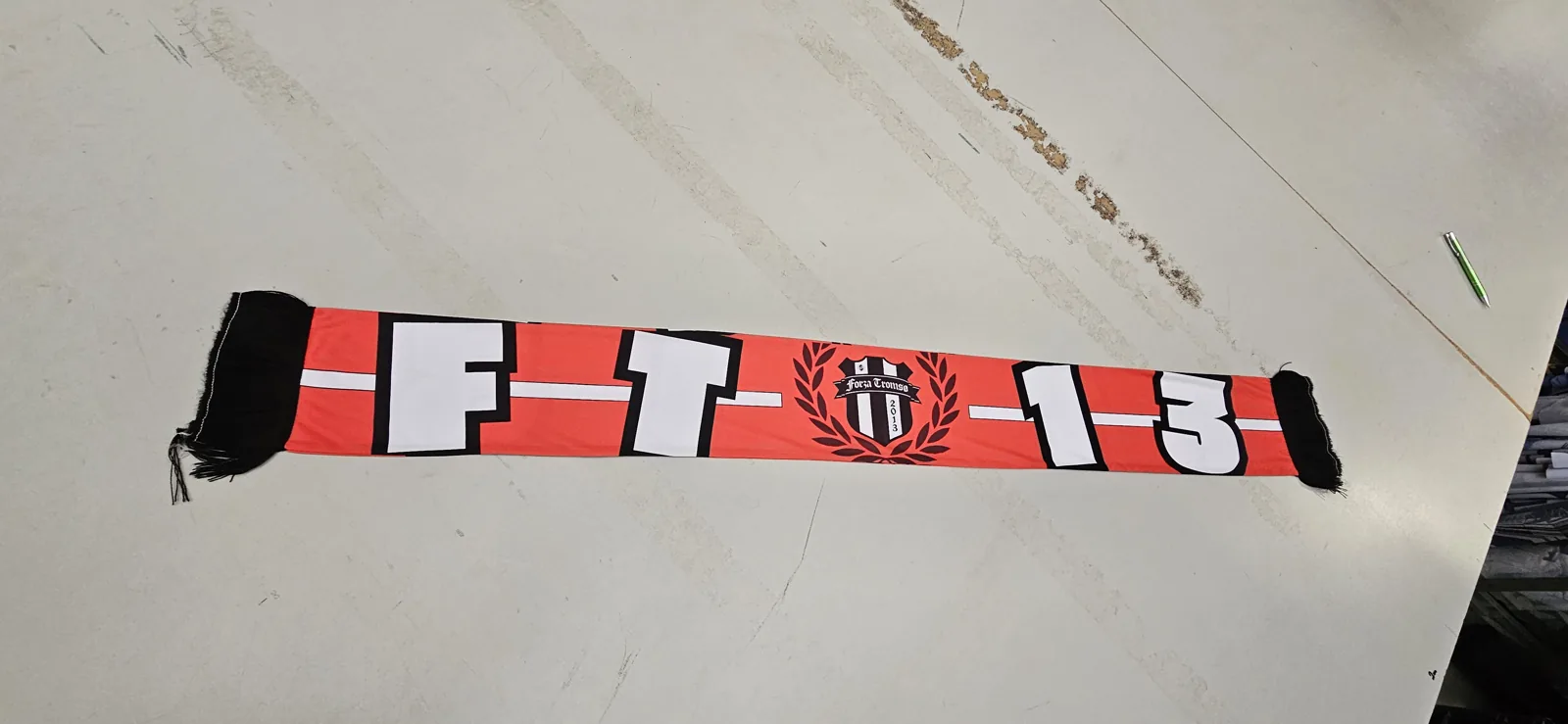 Black and red scarf with the lettering FT 13